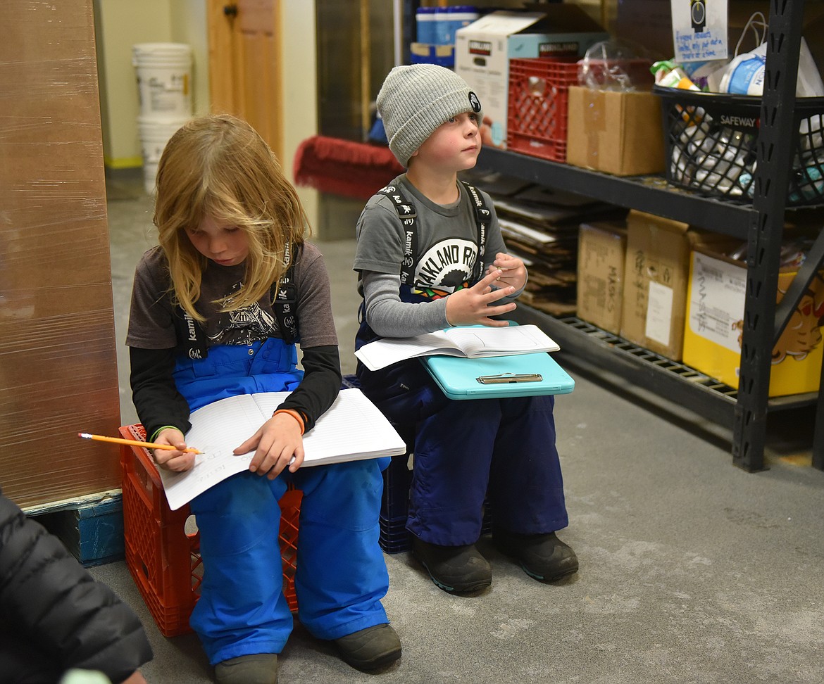 First graders Arlo Crest and Owen Weinberg worked on their drawings during a visit to the food bank in Whitefish. (Julie Engler/Whitefish Pilot)