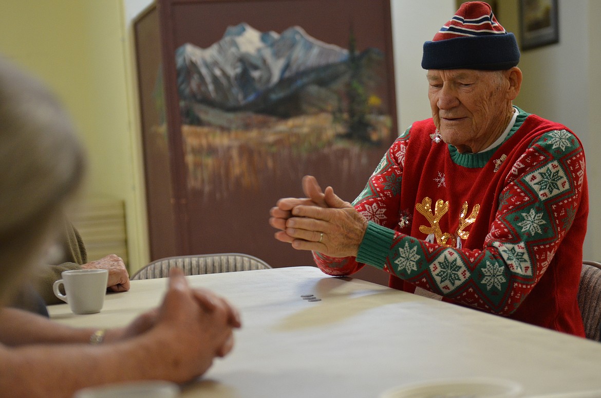 Pic Olsen, who began coming to Leon Hall as a child, rolls the dice at the annual Christmas party. (Kristi Niemeyer/Lake County Leader)