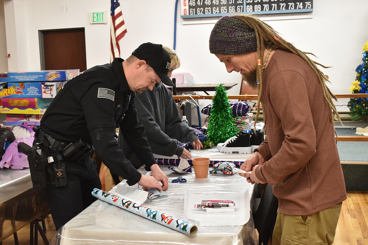 SLPD Officer Robert Geates helps wrap presents.