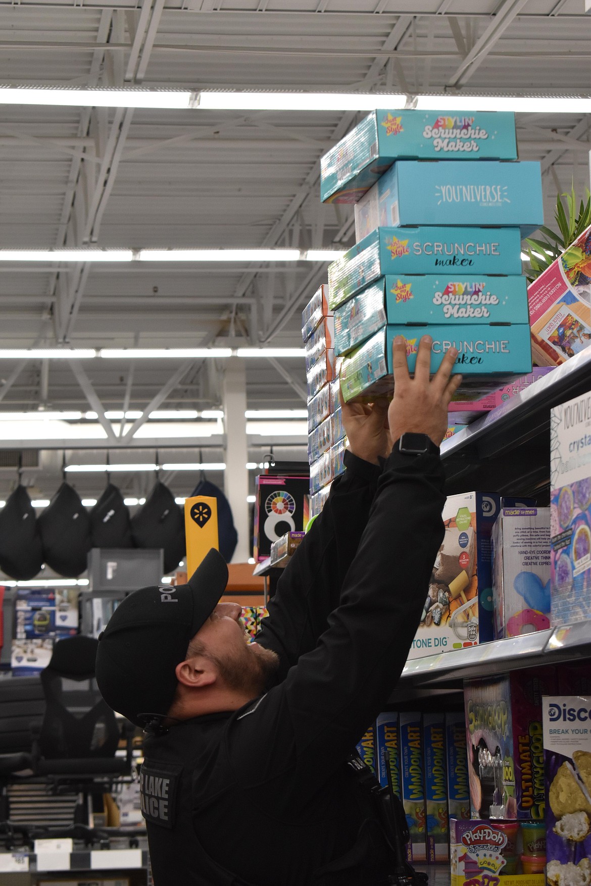 SLPD Officer Dakota Blair pulls a stack of items off a shelf to get to the right toy.