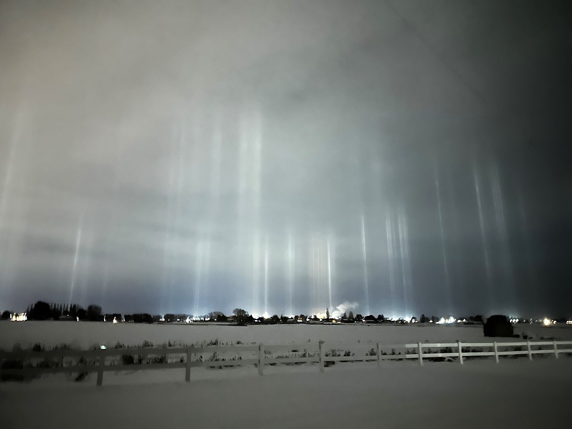 Columns of refracted light appear to erupt through ice crystals over Moses Lake late Friday evening in a photo taken by Brian Nielsen at his home southeast of Moses Lake in a phenomenon known as light pillars.