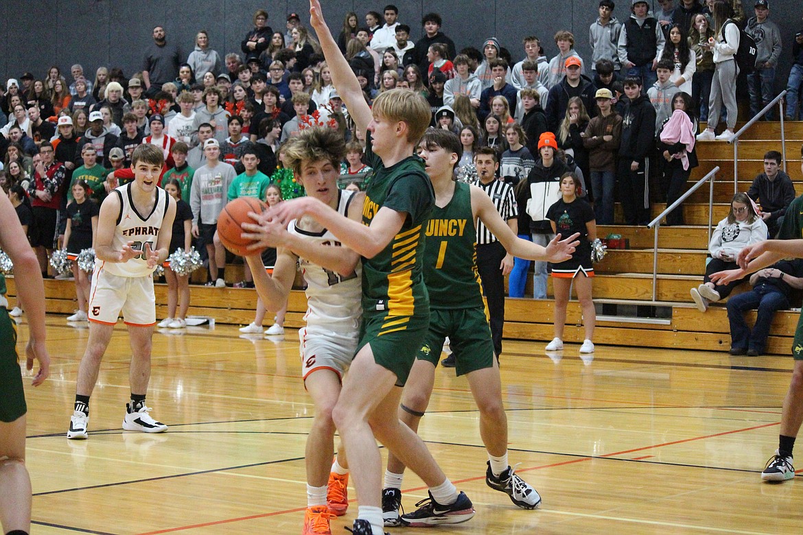 Ephrata’s Hans Roberts, left, is challenged by Quincy’s Aidan Bews, right. Both Quincy and Ephrata are in action this week, playing in holiday tournaments.