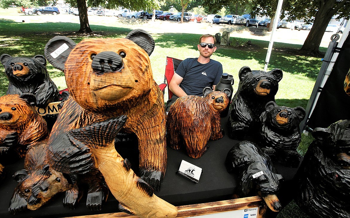 Justin Kowalski sits behind his wood carvings at Taste of Coeur d'Alene in August.