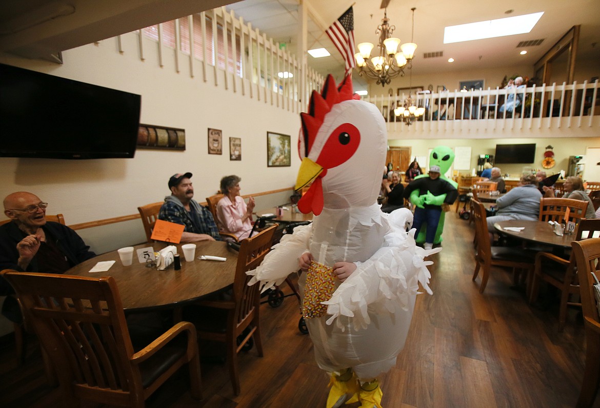 Borah Elementary School fifth grader Silas Brumbaugh, in an inflatable chicken suit, parades with classmates through Bestland Senior Living Community during an all-school Halloween parade.