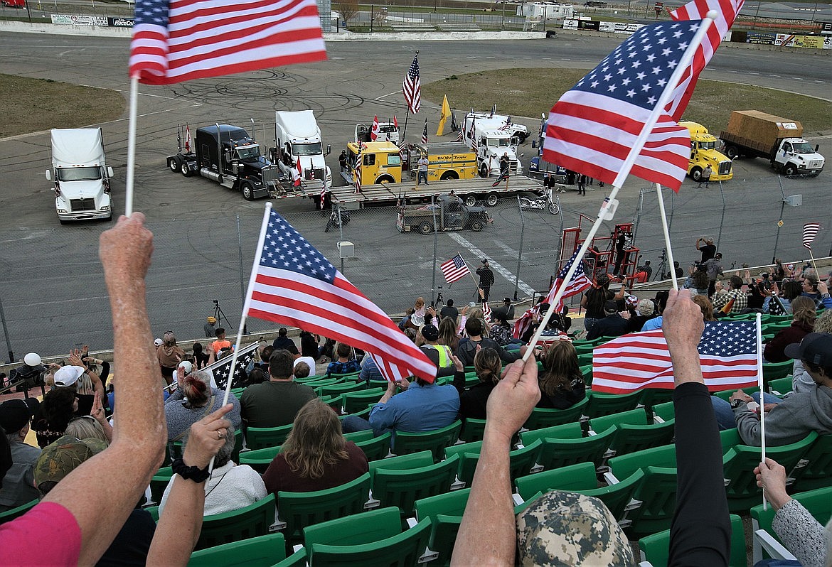 People wave flags at The People's Convoy rally at Stateline Speedway in May.