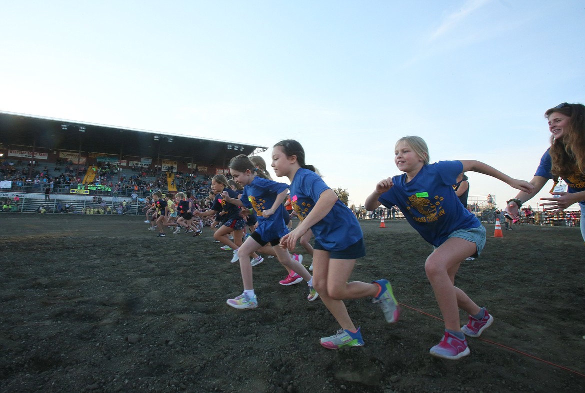 Fourth grade girls race across the arena dirt from the starting line in October during the District 271 Cross Country Race at the Kootenai County Fairgrounds. About 800 students participated.