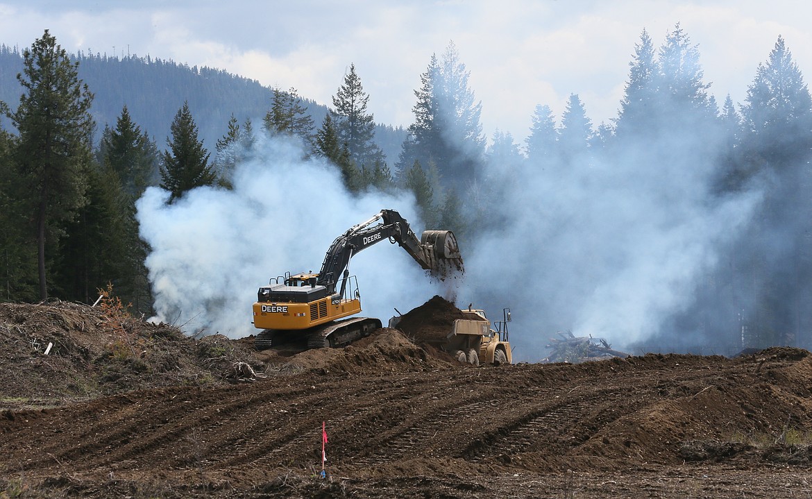 Smoke billows from burn piles April 28 as workers clear land south of Lancaster Road and east of Government Way to make way for the Hayden Canyon master-planned community.