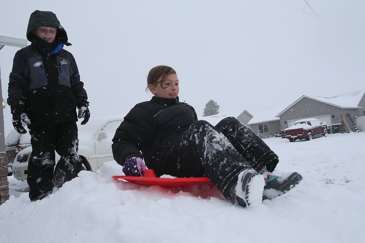 Hadley Still, 8, and Russell Covey, 9, play on a snow mound Nov. 30 in Hadley’s front yard in Post Falls.