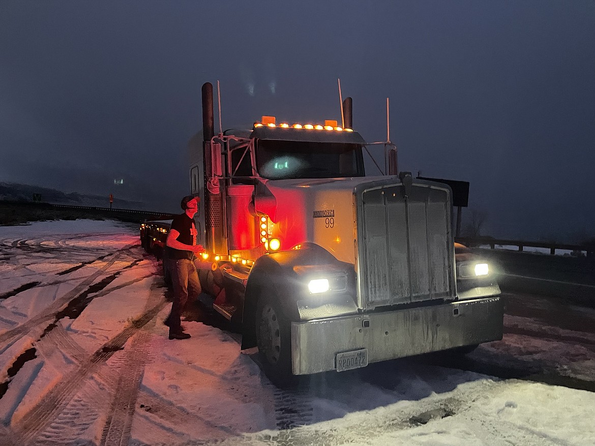 Theron Wood, a truck driver with TL Trucking out of Pasco, prepares to clean the ice off the rearview mirrors of the 1999 Kenworth W900L semi-tractor trailer not far from the junction of S.R. 26 and I-90. Wood had to stop several times on the eastern side of Snoqualmie Pass to clean the ice off his mirrors. “Heated mirrors don’t seem to help,” he said.