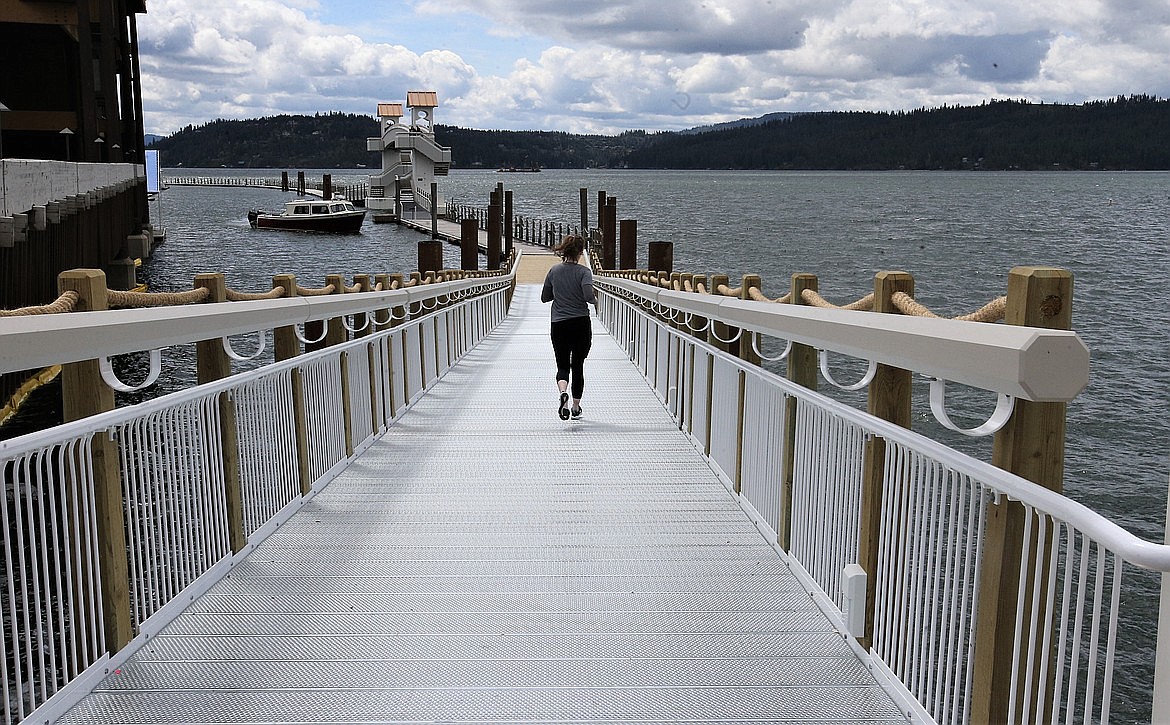 A runner heads out on The Boardwalk, which reopened in May after the wooden west entrance was torn out and replaced with steel railings and walkway.