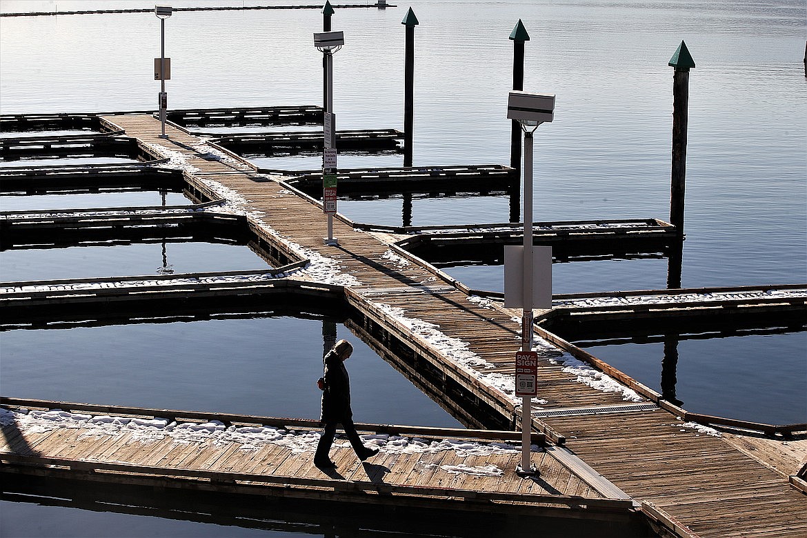 A woman walks Monday on the Third Street mooring docks in Coeur d'Alene in November. The city is seeking a $350,000 state grant to help fund an estimated $500,000 project that would replace the wooden docks installed more than 20 years ago.