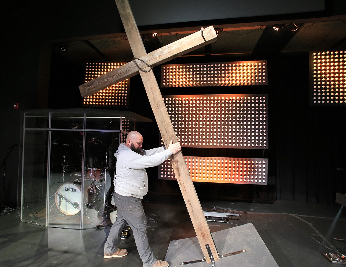 Shawn Frear moves the cross he made for Easter Sunday services at Heart of the City Church.