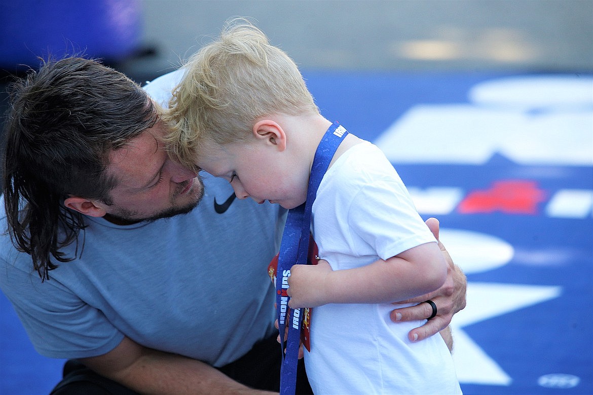 James Griffitts of Coeur d'Alene talks to his son after Beau completed an IronKids run at McEuen Park in June.