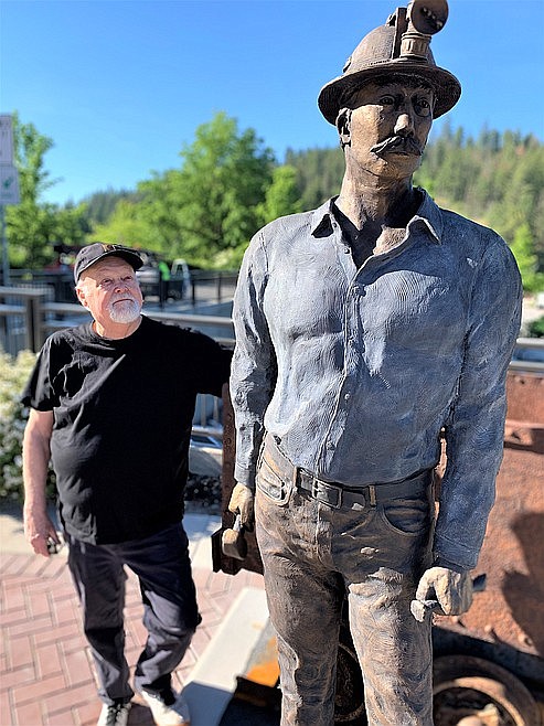 Artist Terry Lee stands by his newest statue, "The Miner," after it was installed on Front Street in Coeur d'Alene in June.