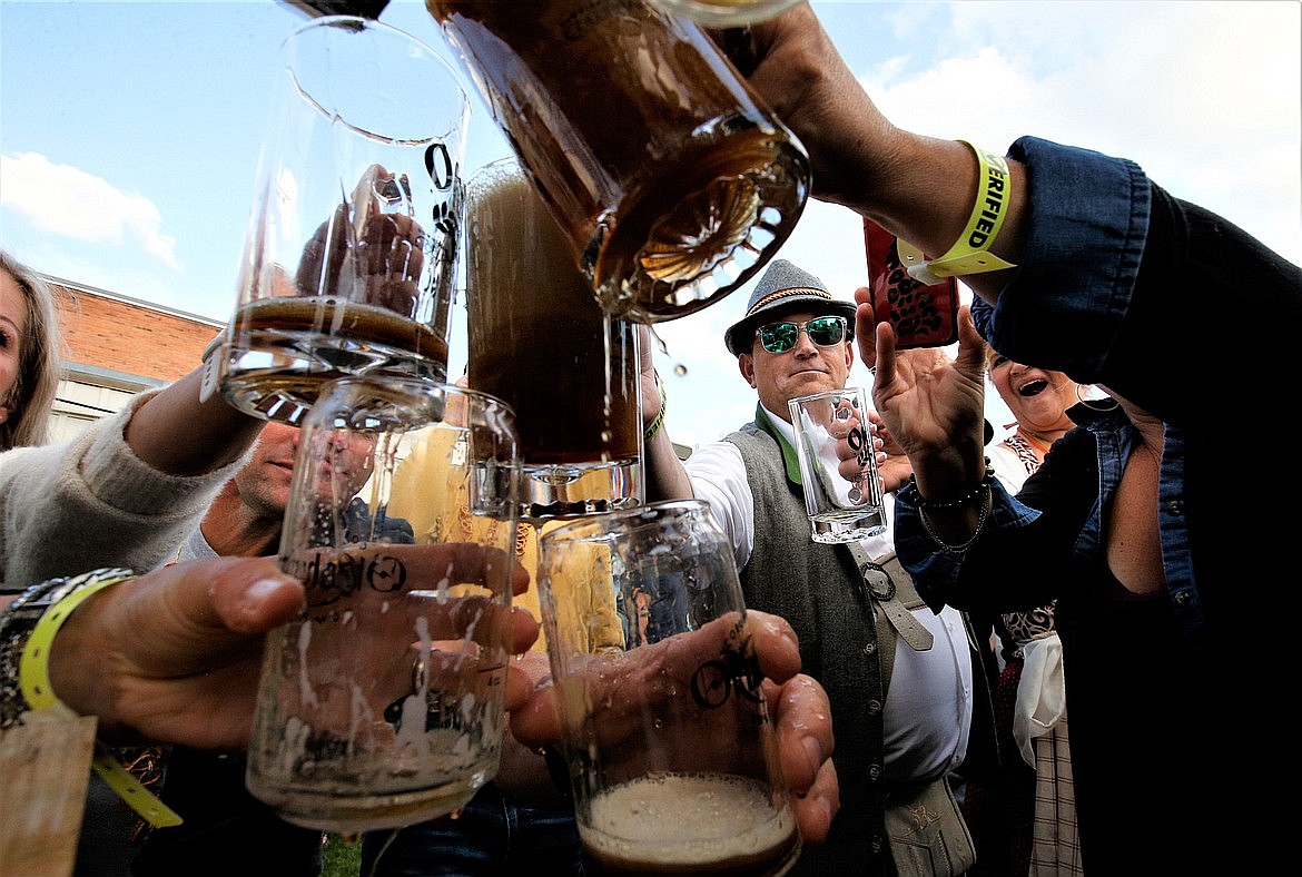 Joel Laker of Coeur d'Alene, wearing glasses, holds up his stein to catch beer during the tapping of the keg that was part of Oktoberfest in downtown Coeur d'Alene.