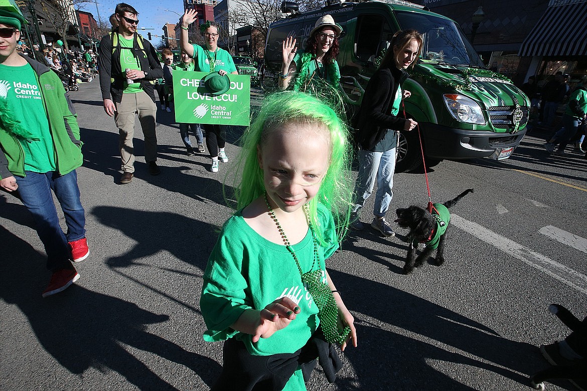 Katharine Munson-Cook, center, holding hat and sign, waves during the St. Patrick's Day Parade on Sherman Avenue in Coeur d'Alene, while daughter Makaylah, with green hair and green fingernails leads the way.