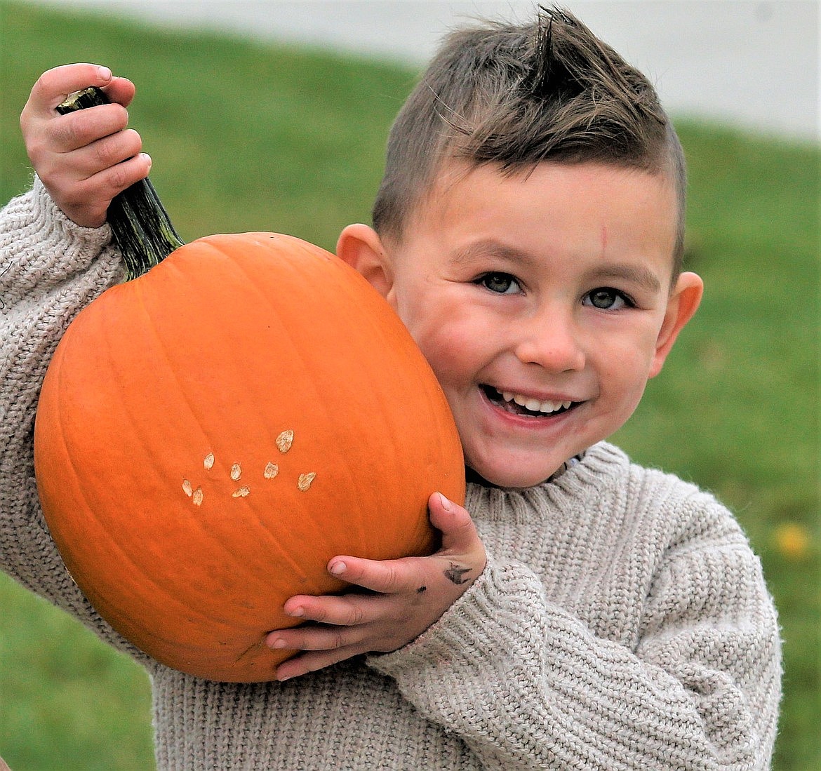 David Perez shows off the pumpkin he selected during a giveaway by the city in October.