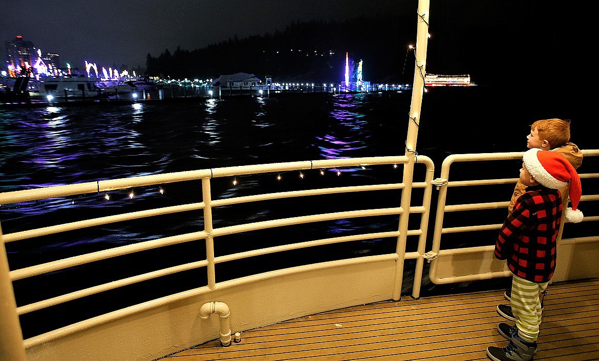 Henry and James Linder of Coeur d'Alene look at the lights and decorations at The Coeur d'Alene Resort as they head out on The Journey to the North Pole Cruise.