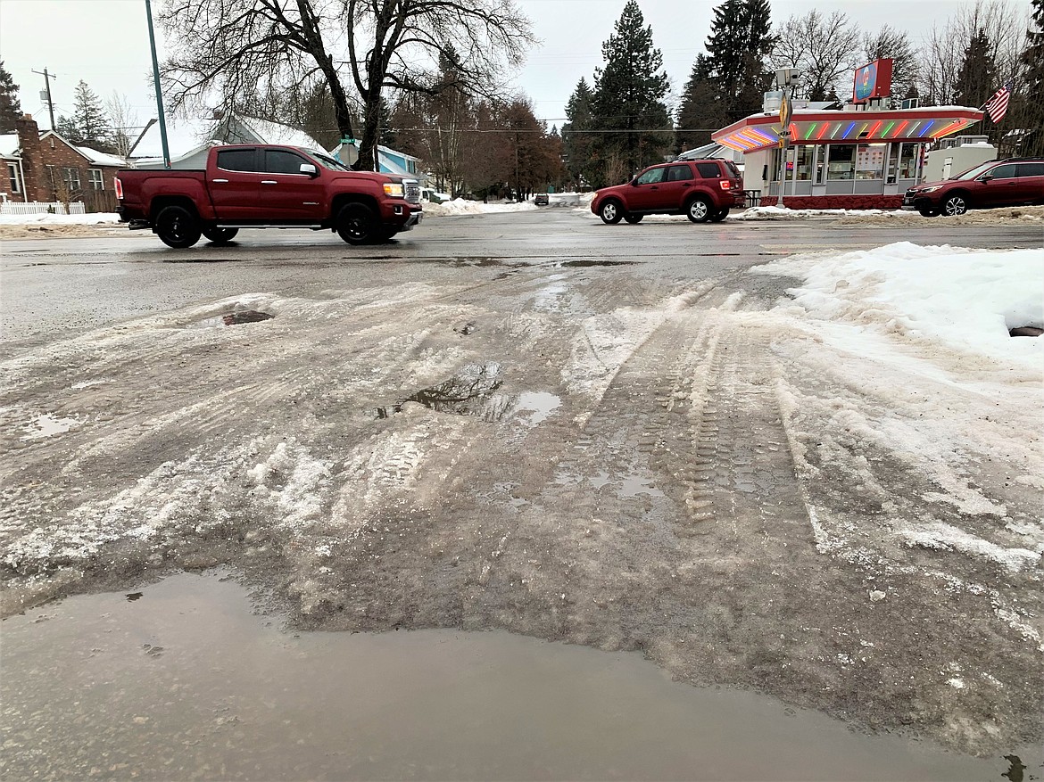 Vehicles pass by puddles, ice and slush across from Roger's Burgers and Ice Cream on Wednesday.