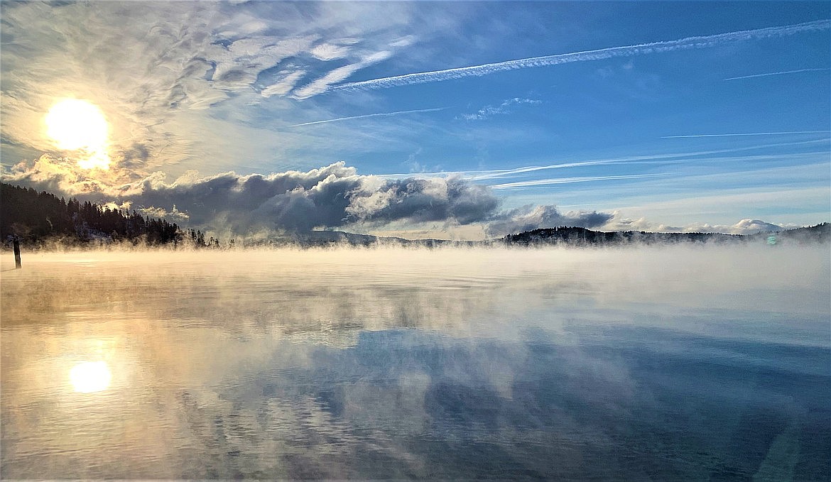 The sun rises over Tubbs Hill as steam rises above Lake Coeur d'Alene in December.