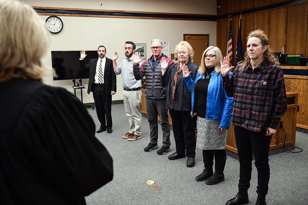 Flathead County District Court Judge Heidi Ulbricht, left, swears in elected officials during a ceremony at the Flathead County Justice Center on Thursday, Dec. 29. Being sworn in are, from left, county attorney Travis Ahner; county justice of the peace Paul Sullivan; county superintendent Cal Ketchum; county commissioner Pam Holmquist; county clerk and recorder Debbie Pierson; and county treasurer Adele Krantz. (Casey Kreider/Daily Inter Lake)