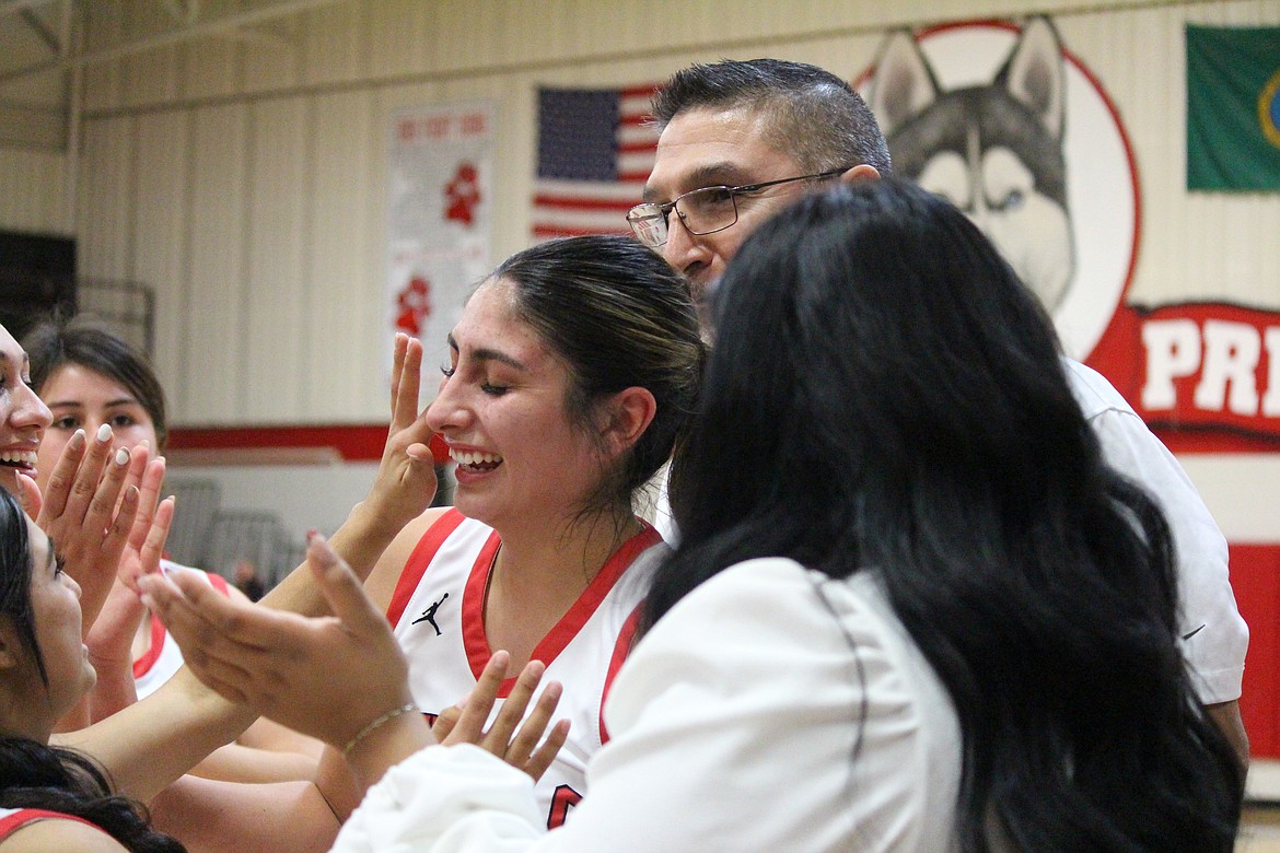 Annalee Coronado (center) is congratulated by her teammates after scoring the 1,000th point in her high school career.