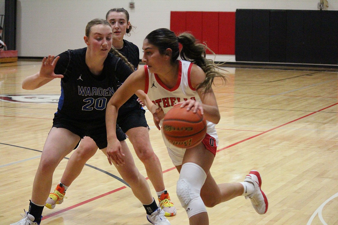 Othello’s Annalee Coronado, in white, works against the defense of Warden’s Molly Sackmann.