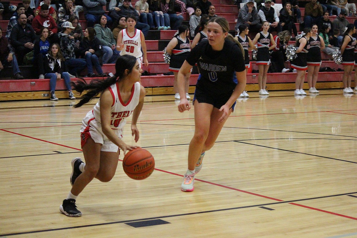 Ruby Trinidad (10) takes the ball upcourt against Lauryn Madsen (0) in Wednesday’s 52-42 Warden win.