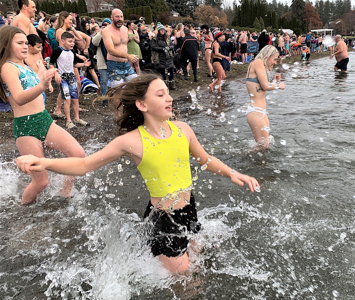 People run into Lake Coeur d'Alene for the Polar Bear Plunge at Sanders Beach on Sunday.