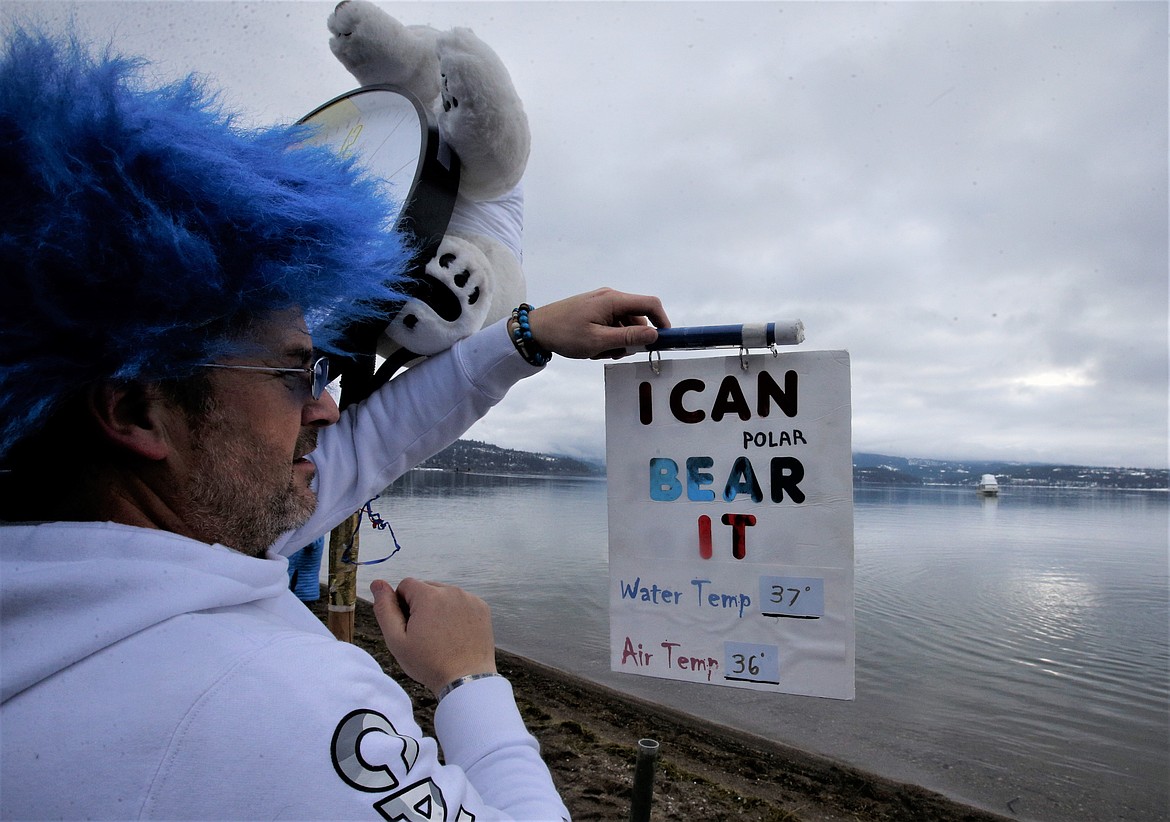 Chad Bennett posts the water and temperature before the Polar Bear Plunge at Sanders Beach on Sunday.