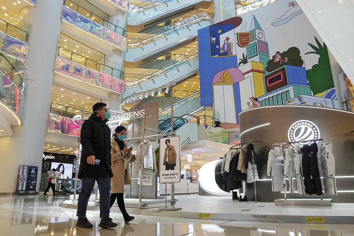 FILE - Shoppers walk through a reopened shopping mall after authorities started easing some of the anti-virus controls in Beijing on Dec. 6, 2022. Chinese manufacturing weakened for a third consecutive month in December, in the biggest drop since early 2020, as the country battles a nationwide COVID-19 surge after suddenly easing its anti-epidemic measures. (AP Photo/Andy Wong, File)