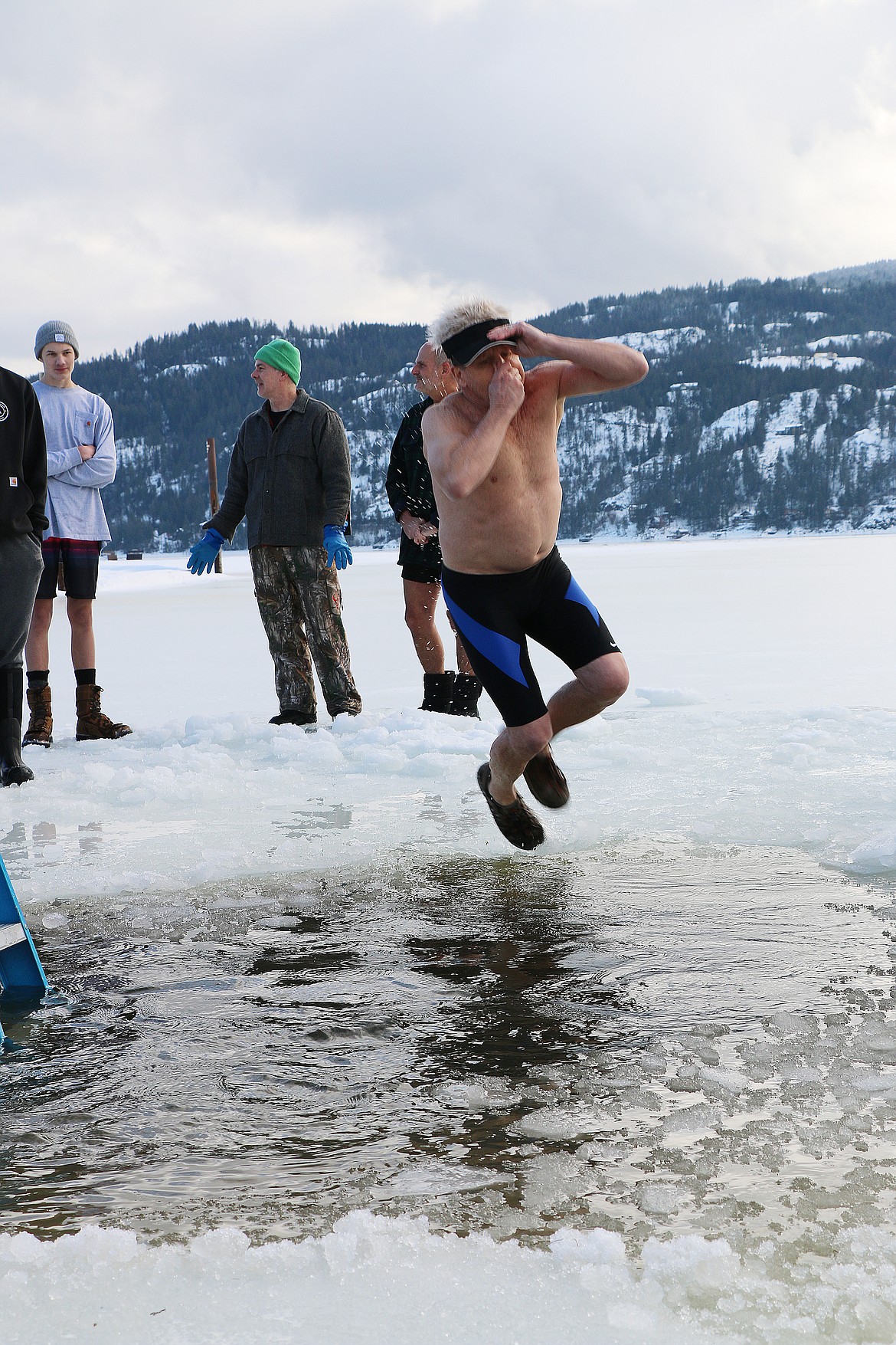 Don Helander plugs his nose as he takes part in the 2023 Polar Bear Plunge on Sunday.