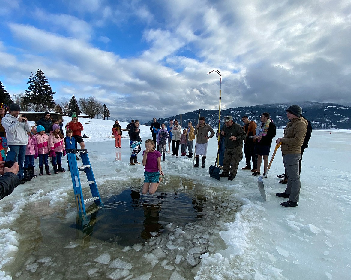 A young Polar Bear Plunge participant plugs her nose and she jumps into Lake Pend Oreille on New Year's Day to kick off 2023 on Sunday.
