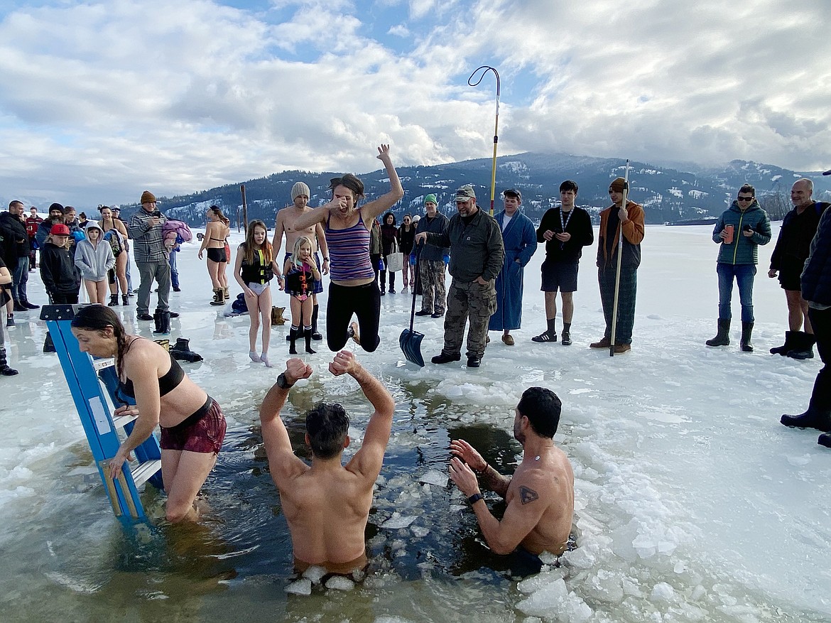A Polar Bear Plunge participant jumps into Lake Pend Oreille as friends cheer her on during the annual event on Sunday.