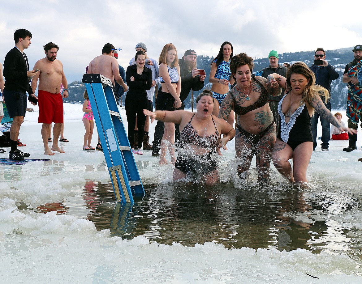 A trio grimaces as they react to the cold water of Lake Pend Oreille during Sunday's Polar Bear Plunge.