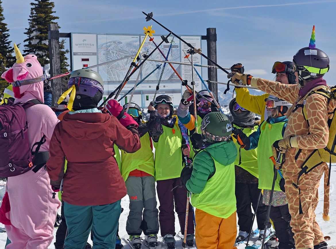 SheJumps Junior Ski Patrol Day participants share a high five at the summit. (Julie Engler/Whitefish Pilot)