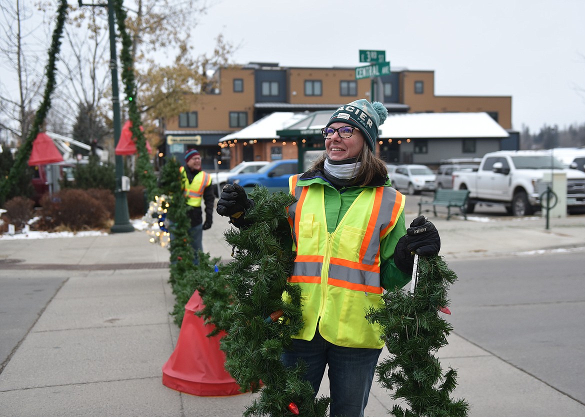 A volunteer helps with a garland. (Julie Engler/Whitefish Pilot)