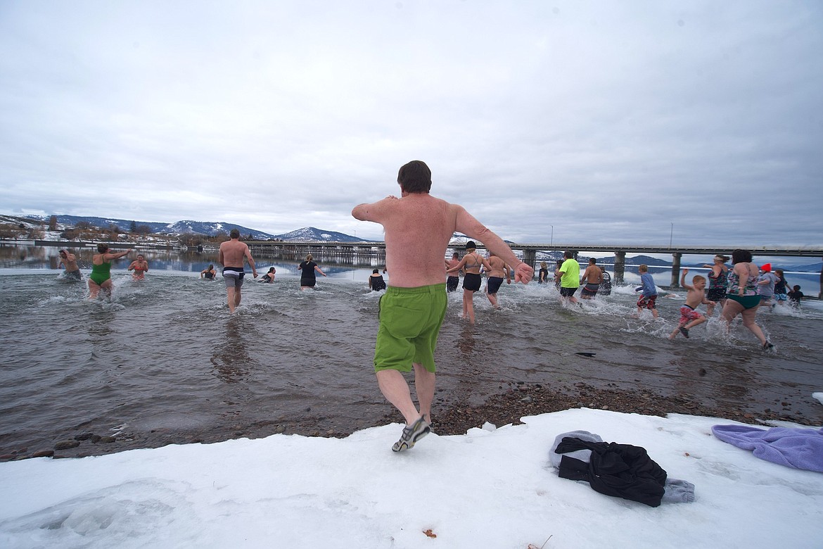Dave Bull (green trunks) follows fellow plungers into the 30-degree water at Riverside Park Sunday during the 25th Polar Plunge. (Kristi Niemeyer/Lake County Leader)