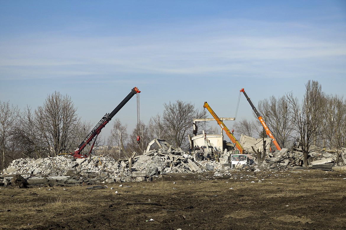 Workers clean rubbles after Ukrainian rocket strike in Makiivka, in Russian-controlled Donetsk region, eastern Ukraine, Tuesday, Jan. 3, 2023. Russia's defense ministry says 63 of its soldiers have been killed by a Ukrainian strike on a facility in the eastern Donetsk region where military personnel were stationed. (AP Photo)