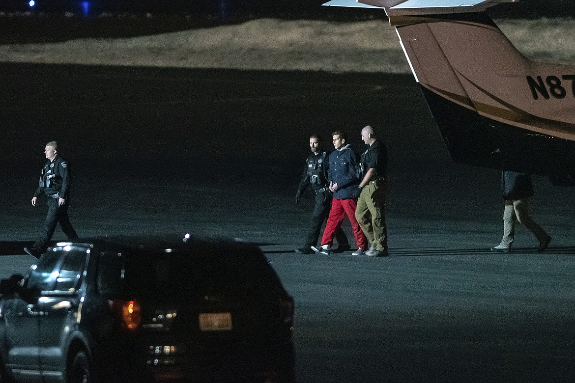 Bryan Kohberger is escorted by law enforcement after arriving at Pullman-Moscow Regional Airport on Thursday in Pullman. Kohberger was extradited from Pennsylvania earlier Thursday, for the alleged murder of four University of Idaho students on Nov. 13.