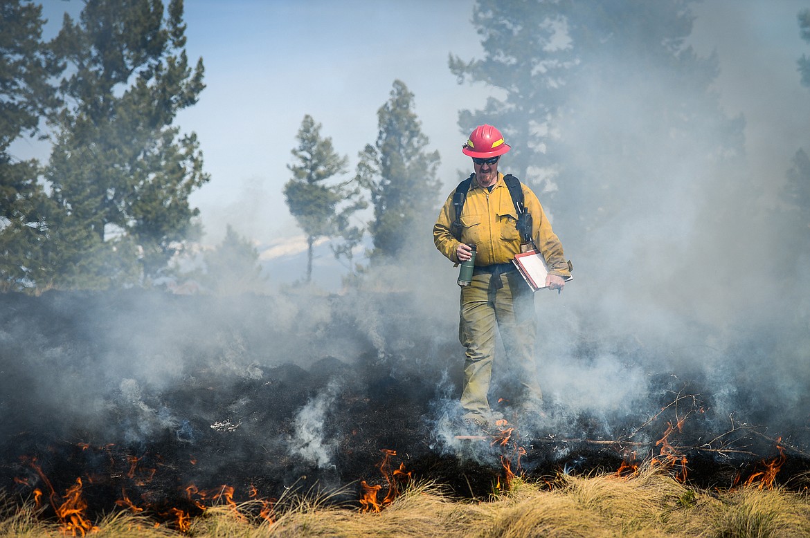 Aaron King, burn boss with the Montana DNRC, checks an area of the fire during a prescribed burn at Lone Pine State Park in Kalispell on Thursday, April 7. (Casey Kreider/Daily Inter Lake)