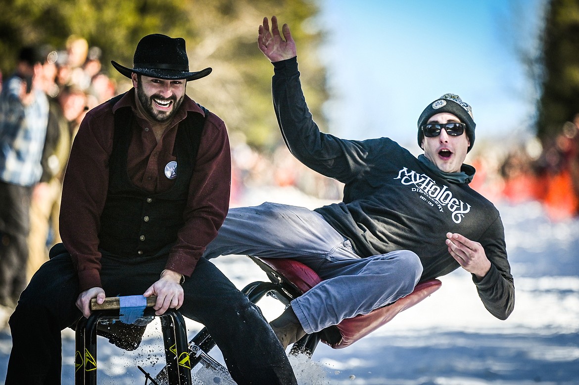 Jonny Highfill, right, falls off his barstool racer as he races against Chronicles of Barnia at the Barstool Ski Races during the 43rd annual Cabin Fever Days in Martin City on Saturday, Feb. 12. (Casey Kreider/Daily Inter Lake)