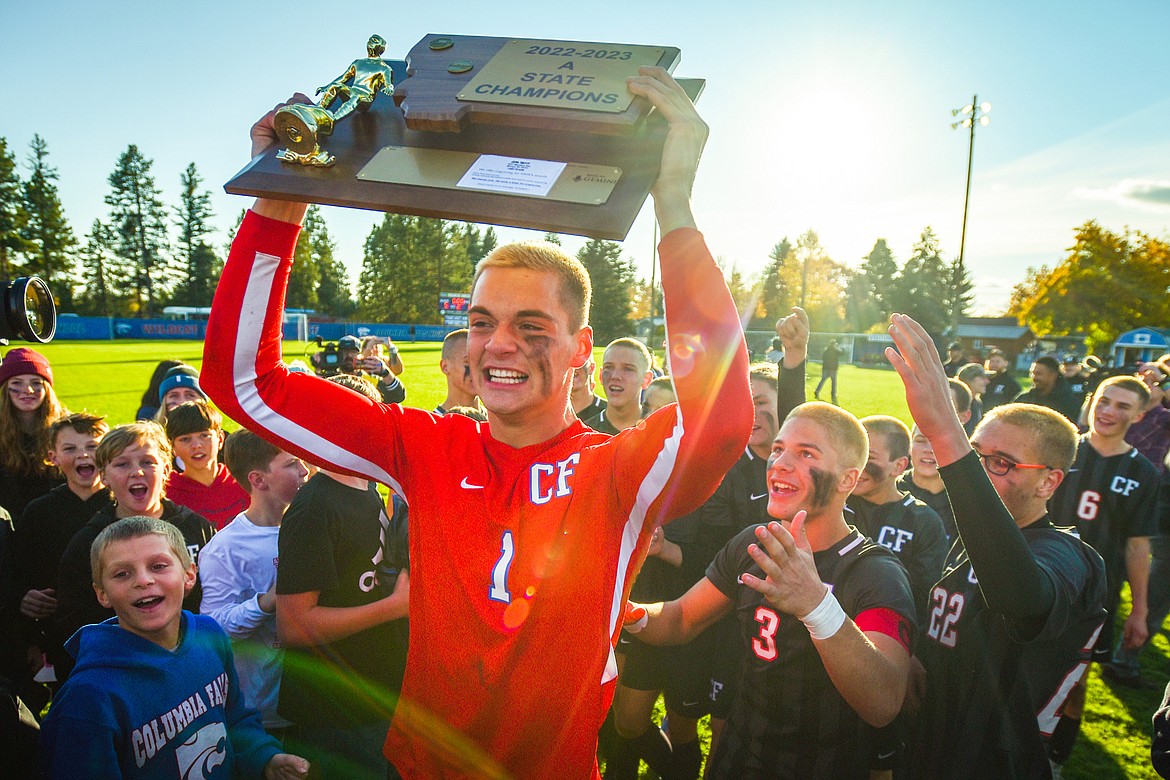 Columbia Falls goalkeeper Bryce Dunham (1) celebrates with the state championship trophy after the Wildcats' 5-2 win over Livingston at Flip Darling Memorial Field in Columbia Falls on Saturday, Oct. 29. (Casey Kreider/Daily Inter Lake)