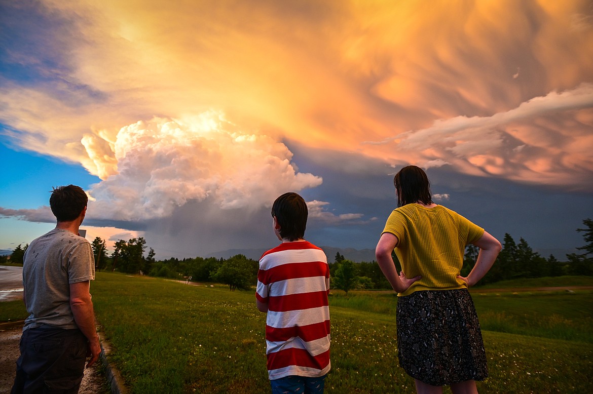 Jeremy, Toby and Mailli Brown watch storm clouds from Dry Bridge Park after a hail storm in south Kalispell on Thursday, July 7. (Casey Kreider/Daily Inter Lake)