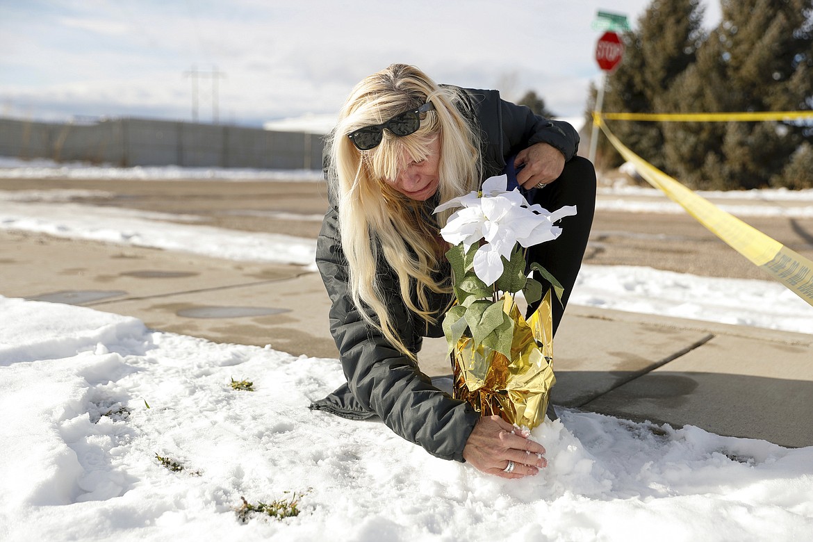 Sharon Huntsman, a member of The Church of Jesus Christ of Latter-day Saints from Cedar City, Utah, leaves flowers outside a home where eight family members were found dead in Enoch, Utah, Thursday, Jan. 5, 2023. Officials said Michael Haight, 42, took his own life after killing his wife, mother-in-law and the couple's five children. (Ben B. Braun/The Deseret News via AP)