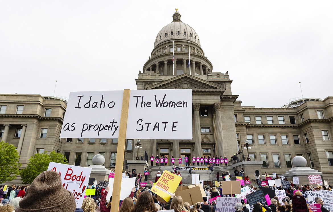 An attendee at Planned Parenthood's Bans Off Our Bodies rally for abortion rights holds a sign reading "Idaho the women as property state" outside of the Idaho Statehouse in downtown Boise in mid-May 14. Idaho's Constitution does not implicitly enshrine abortion as a fundamental right, the state Supreme Court ruled on Thursday as it dismissed a lawsuit brought by Planned Parenthood.