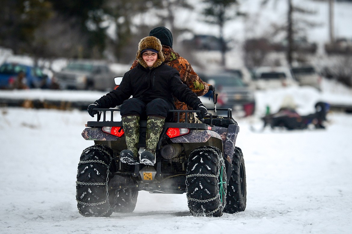 A child smiles as he gets a ride back to shore at the Sunriser Lions Family Ice Fishing Derby at Smith Lake on Saturday, Jan. 7. (Casey Kreider/Daily Inter Lake)