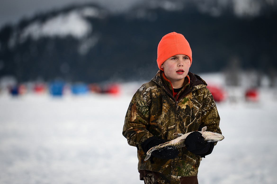 Lucas West carries a pike to be weighed at the Sunriser Lions Family Ice Fishing Derby at Smith Lake in Kila on Saturday, Jan. 7. (Casey Kreider/Daily Inter Lake)