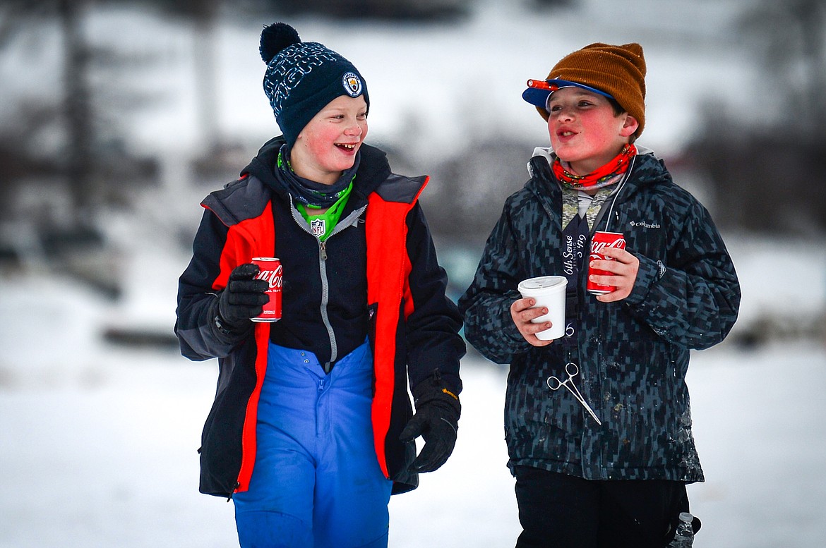 Mason Billiet, left, and Kwintyn Hicks walk and talk as they take a break from reeling in pike at the at the Sunriser Lions Family Ice Fishing Derby at Smith Lake on Saturday, Jan. 7. (Casey Kreider/Daily Inter Lake)