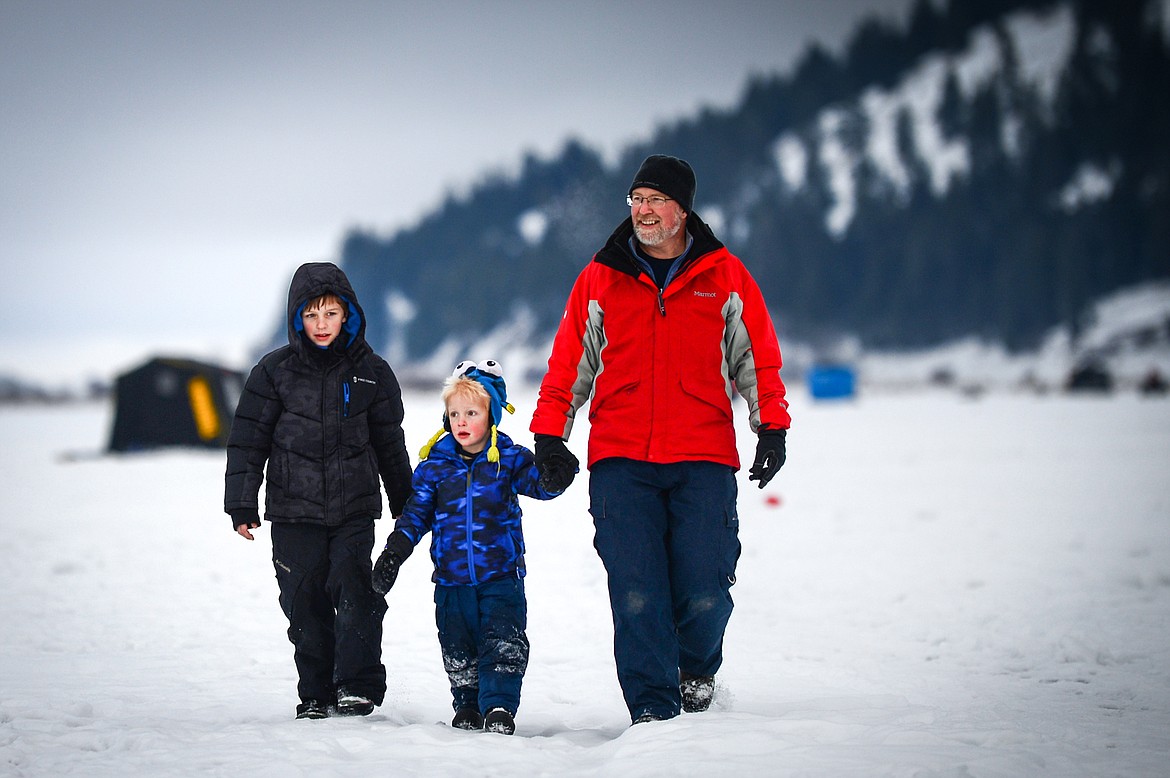 Tim Eichner walks to shore with his sons Conrad, left, and Chester at the Sunriser Lions Family Ice Fishing Derby at Smith Lake on Saturday, Jan. 7. (Casey Kreider/Daily Inter Lake)